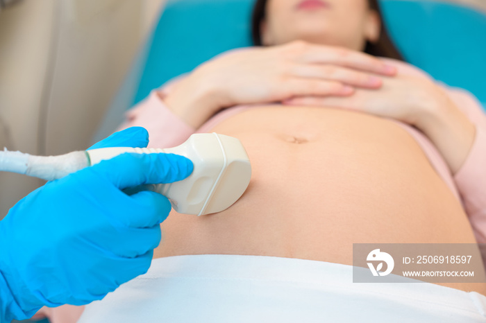 close-up shot of obstetrician gynecologist making of ultrasound examination pregnant woman