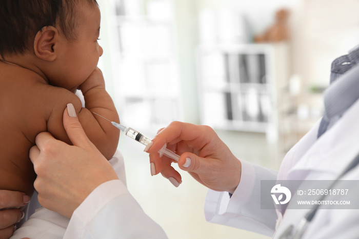 Pediatrician giving little baby an injection in clinic