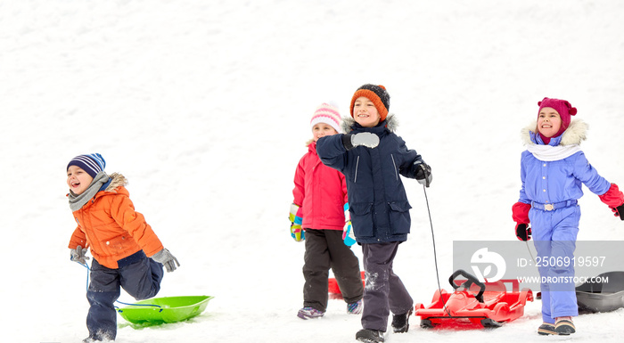 童年、雪橇和季节概念——一群快乐的孩子在冬天玩雪橇