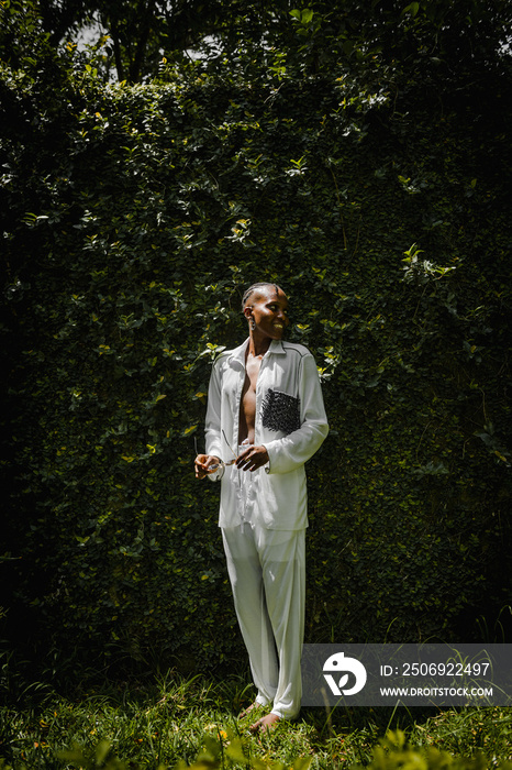 a black woman dressed fashionable posing for a portrait in a garden