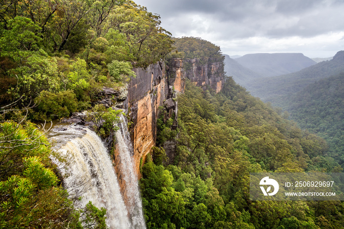 Fitzroy water falls thundering over rock face into forested canyon in Kangaroo Valley, NSW, Australi