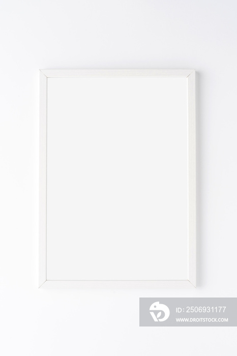Empty picture frame on white wall. Mockup with copyspace