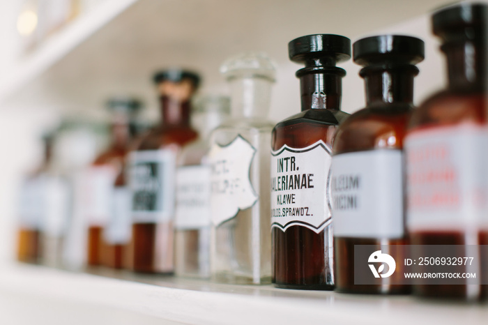 Vintage stylish glass bottles with pharmaceutical substances on the shelf in old pharmacy