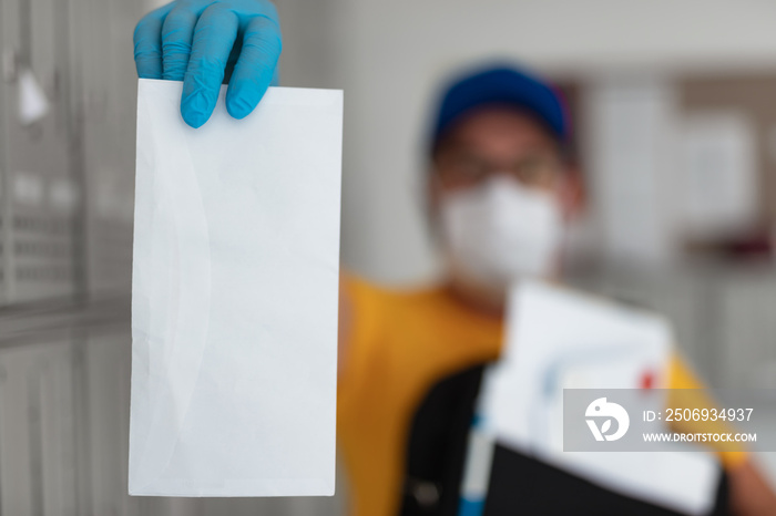 Mailman delivering mail with mail-bag and protective mask and gloves during virus pandemic.