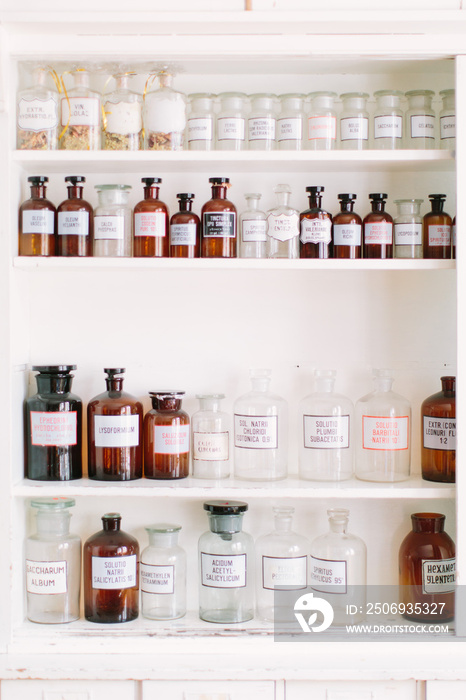 Vintage stylish glass bottles with pharmaceutical substances on the shelf in old pharmacy