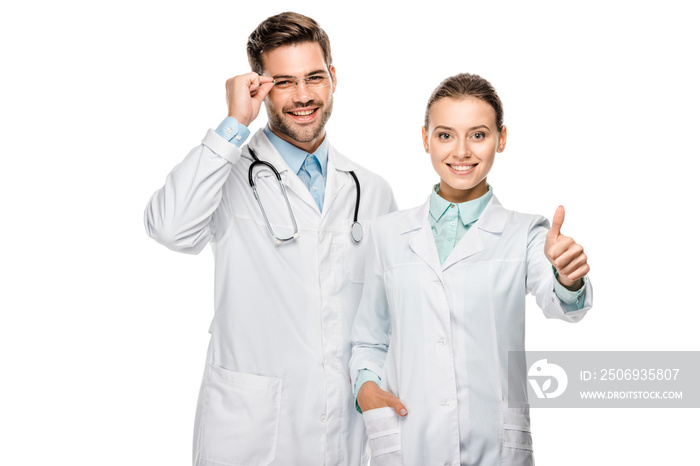 attractive female doctor doing thumb up gesture while her male colleague standing near isolated on w