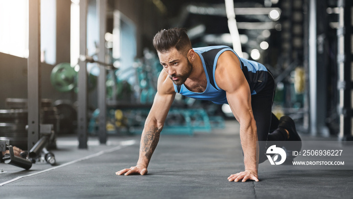 Muscular guy preparing for hard workout in gym