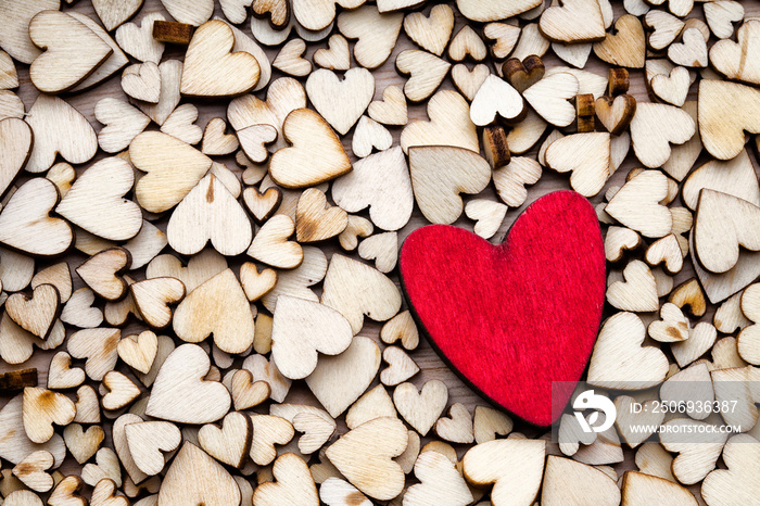 Wooden hearts, one red heart on the heart background.