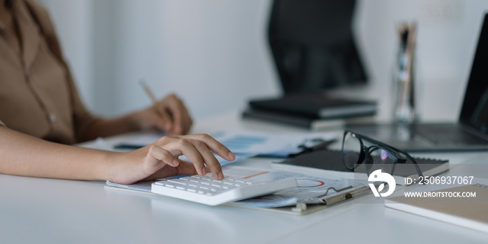 Financial woman use laptop and calculator to analyze marketing strategies and real estate data to re