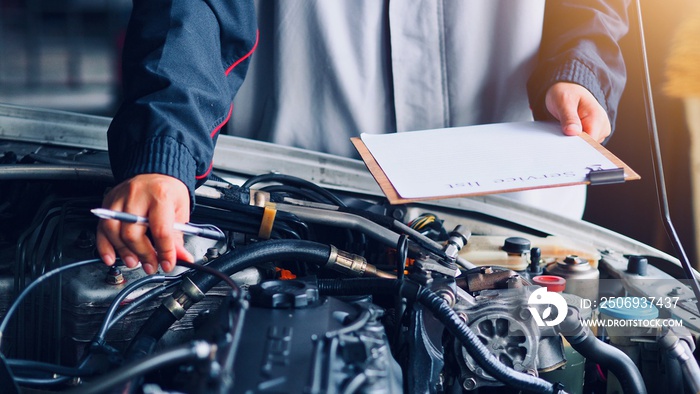 Car care, car mechanic are waiting to check the engine and record the information on the service lis