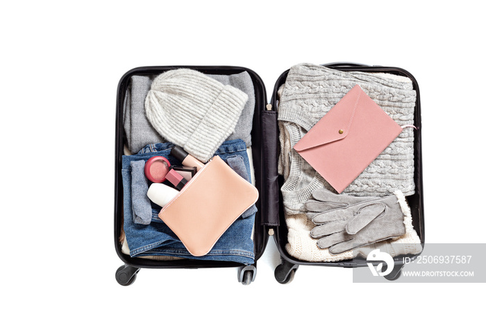 Flat lay with open suitcase with casual clothes for autumn, winter vacations over white background