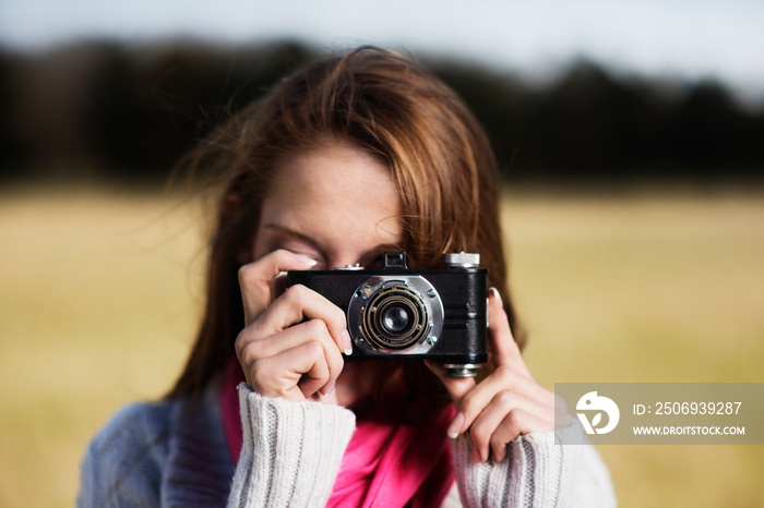 Woman taking picture in field