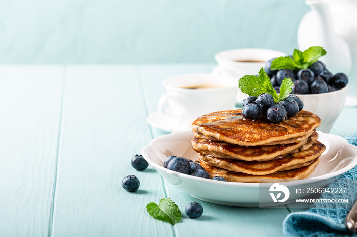 Delicious pancakes with chocolate drops, honey and blueberries. Healthy breakfast concept with copy 