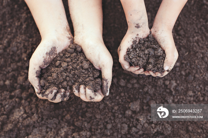 父母和孩子手拿心形土壤，用复古色调一起种植