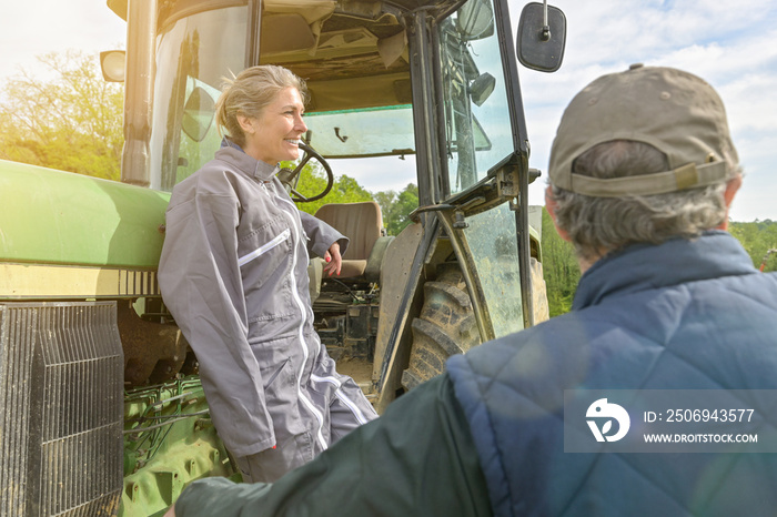 Woman farmer listening the instruction from her boss before to leave the farm  with her tractor