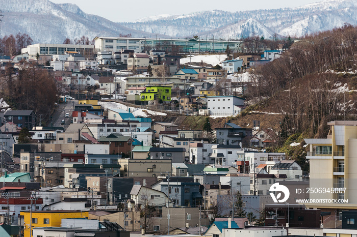 日本北海道冬季以雪山为背景的城市景观。