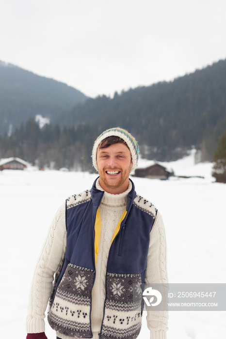 Portrait happy young man in snowy field