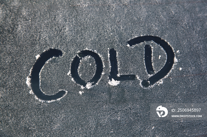 Frozen car window with a frost message of a cold text sign during bad weather in the winter season, 