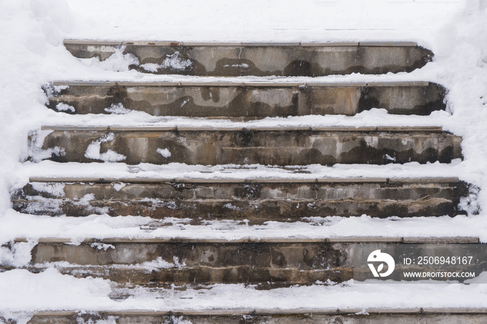 Staircase on the street in the snow and steps marked with snow with traces of people