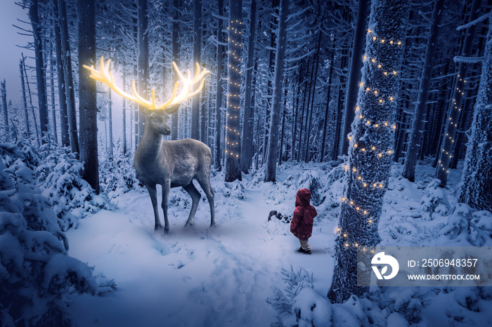 Ein Hirsch mit gold leuchtendem Geweih steht in einem kalten Winterwald vor einem kleinen Kind