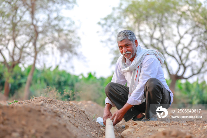 Indian / Asian Farmer checking water tube at field