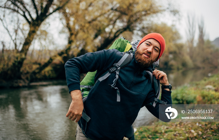 年轻徒步旅行者男性背着旅行背包在山上徒步旅行的照片。留着胡子的旅行者放松着af