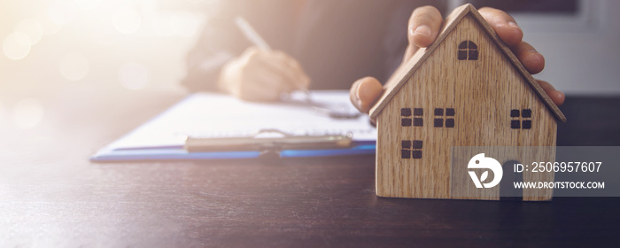 房地产、物业和房主签订合同概念，办公楼上的小木屋模型