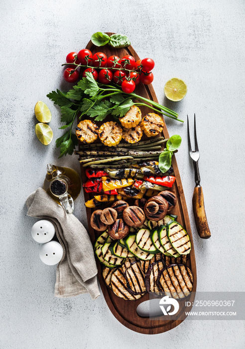 一个大木托盘，里面有夏季小吃、五颜六色的烧烤蔬菜、樱桃番茄和绿色蔬菜。s
