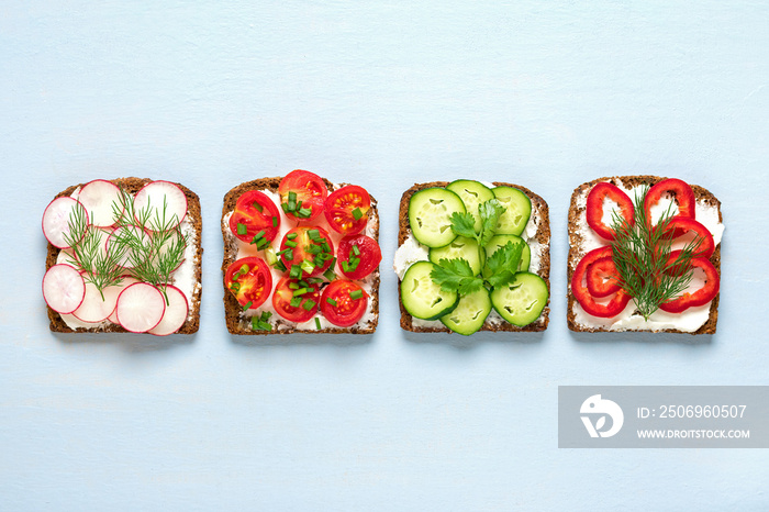 Variety of sandwiches for breakfast - slice of whole grain dark bread, pepper, cream cheese, cucumbe