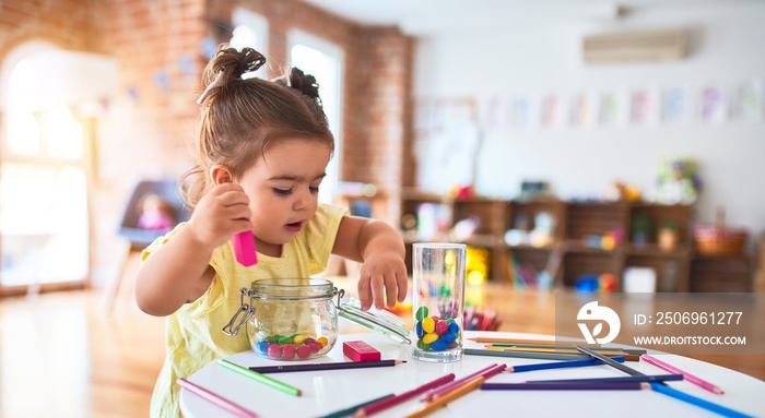 幼儿园漂亮的蹒跚学步的孩子在桌子上玩木制积木