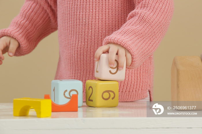 Toddler girl playing with wooden blocks