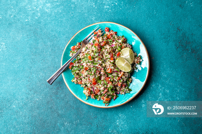 Traditional Lebanese salad tabouli tabule with quinoa, herbs, tomatoes, mint and lemon