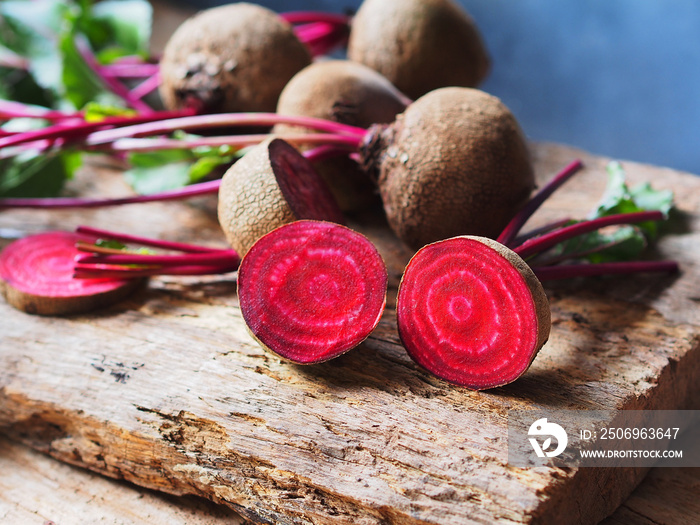 Fresh beetroot cut in half on a rustic wooden table for healthy food or vegetable concept.