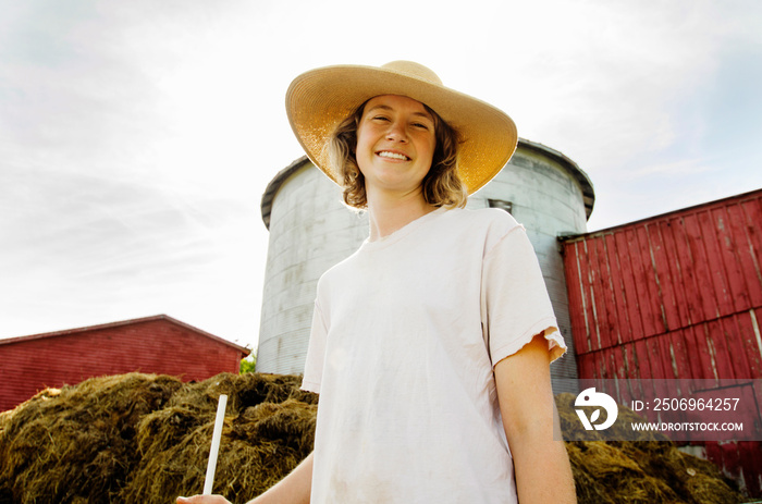 Portrait of woman standing against barn