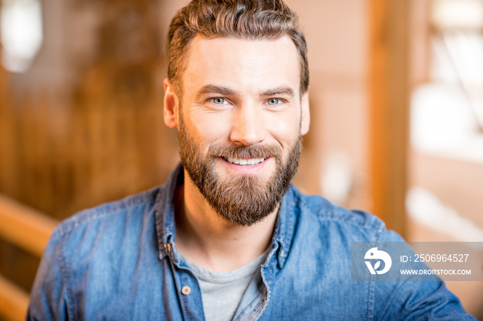 Close-up portrait of a handsome businessman or farmer indoors in the barn