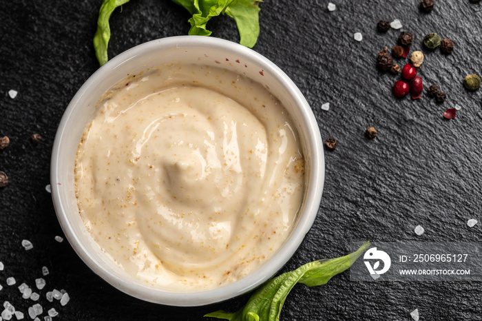 Bowl with garlic sauce on dark background. Food recipe background. Close up