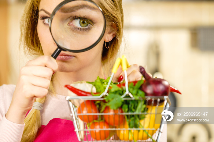 Woman investigating shopping backet with vegetables