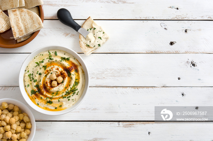 Hummus in bowl on white wooden table