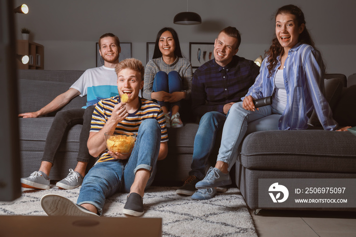 Friends watching TV at home in evening