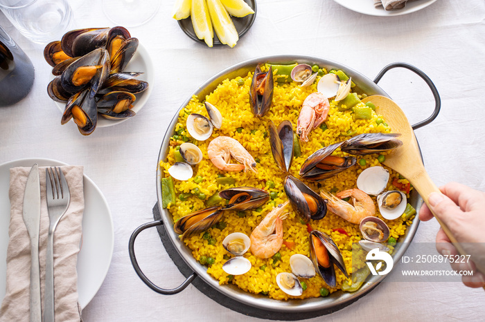 Top view of Seafood Paella with  prawns, clams, mussels on saffron rice and vegetables served in  tr