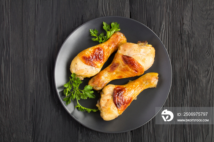 Top view of fried chicken legs in the frying pan on the black plate with copy space