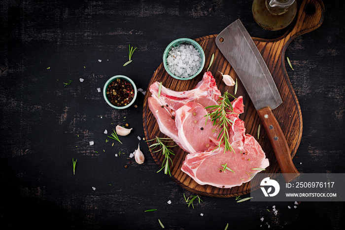 Raw pork steaks оn the dark table. Top view, overhead, copy space