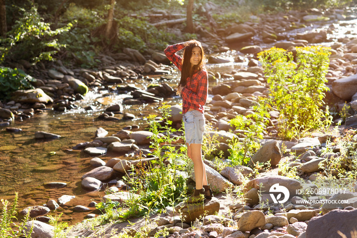 Smiling young woman standing on riverbank