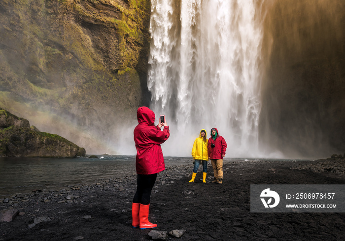 friends are photographed before a waterfall in Iceland