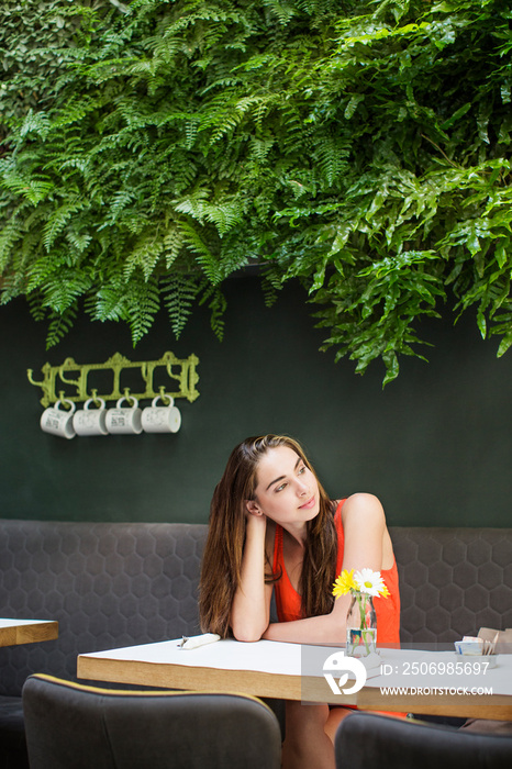 Woman contemplating in sidewalk cafe