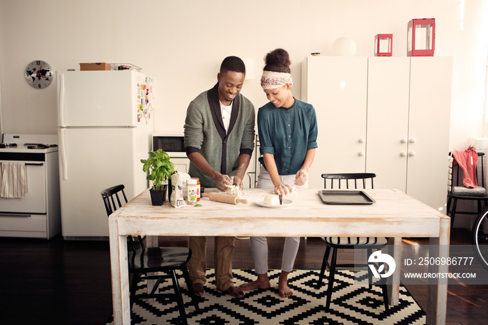 Smiling couple preparing food at home