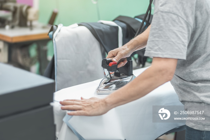 ironing a garment in industrial tailoring production line