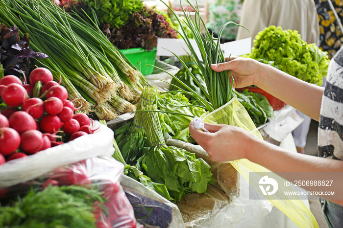 Woman with eco bag buying vegetables in supermarket