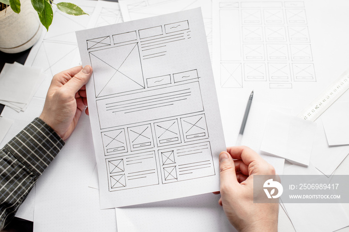 UX website designer drawing wireframe sketch of prototype, framework, layout future project. Creativ