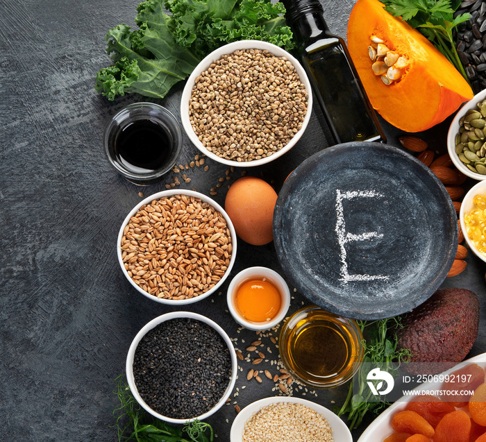 Foods high in vitamin E on dark background.